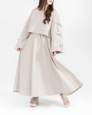 Woman wearing a antic beige dress set with a long skirt on a white background