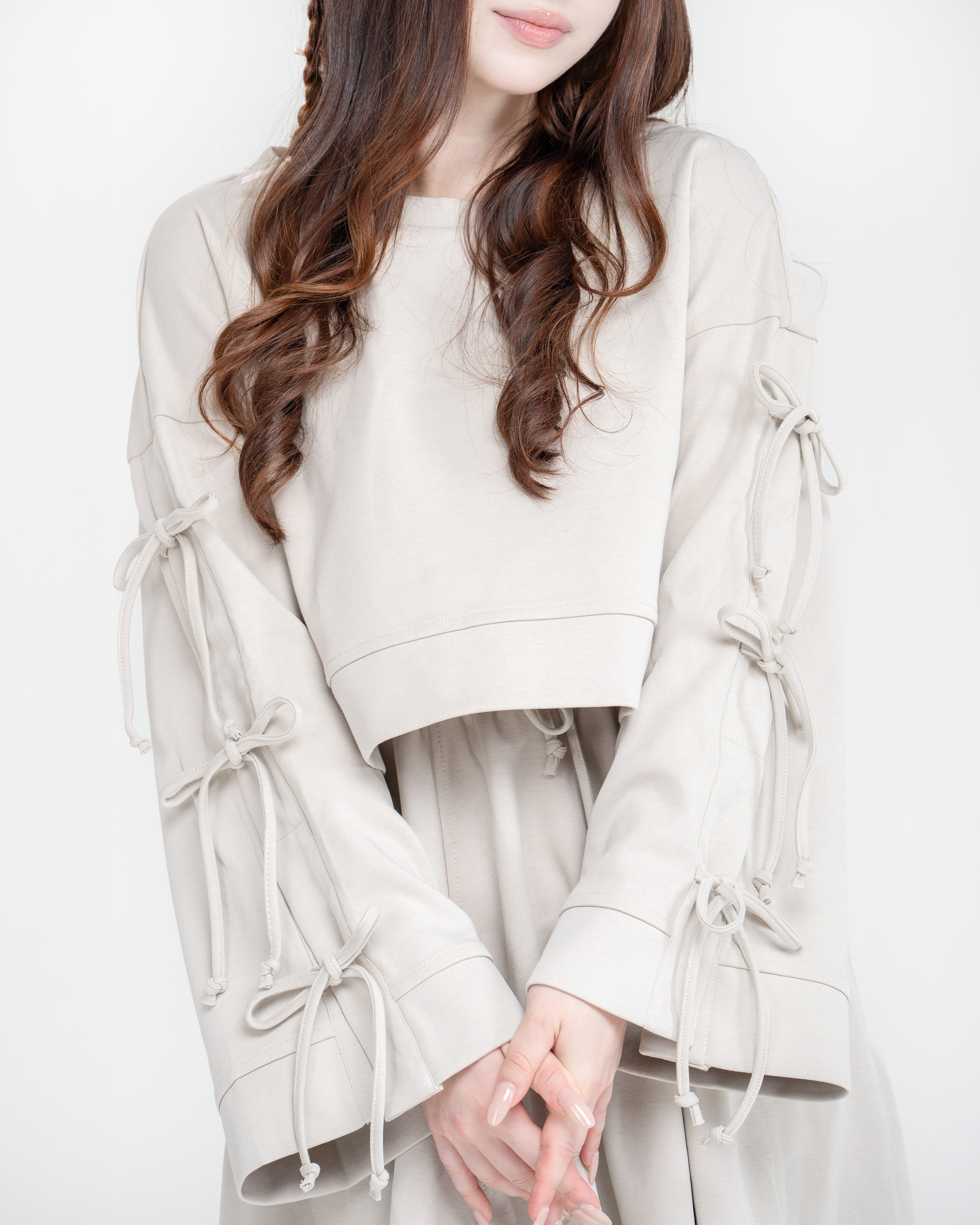 Woman wearing a antic beige dress set with a long skirt on a white background