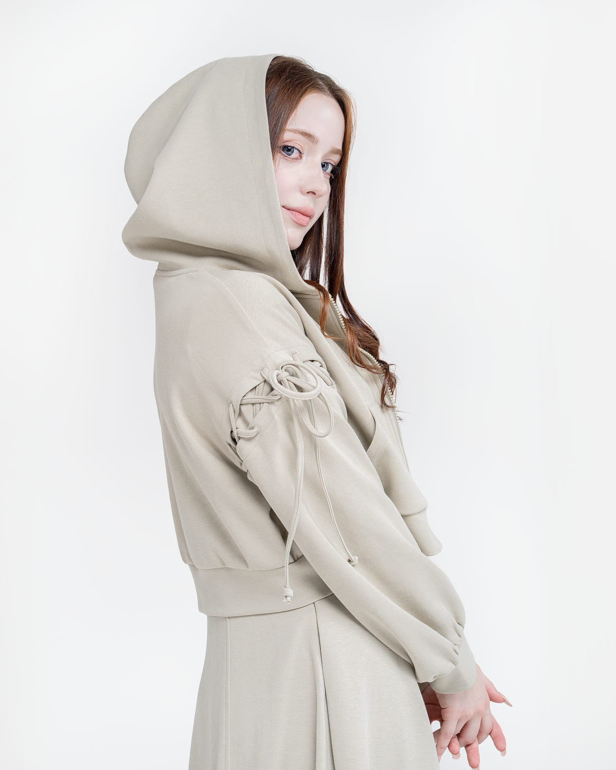 Woman wearing the pistachio Luna hoodie with the hood up, bows on the sleeves
